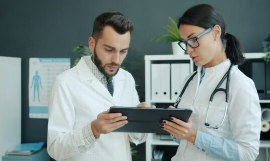 Two clinicians reviewing provider information on a tablet