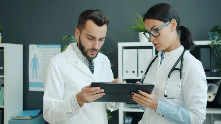 Two clinicians reviewing provider information on a tablet