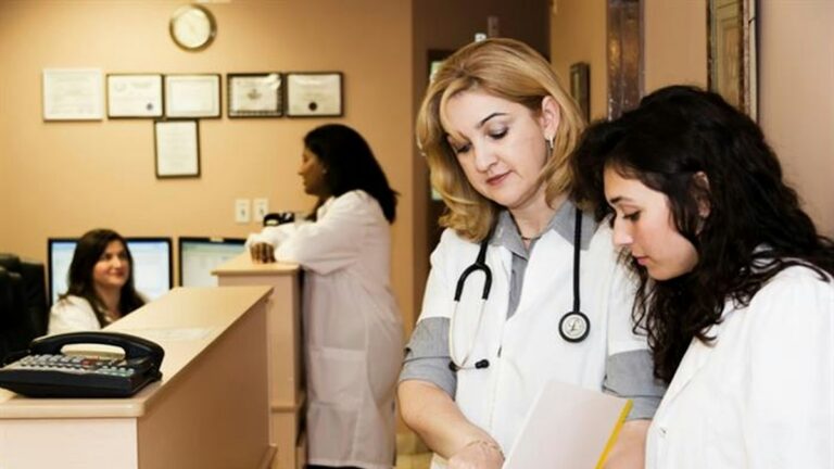Healthcare staff reviewing provider credentialing records at a clinic desk