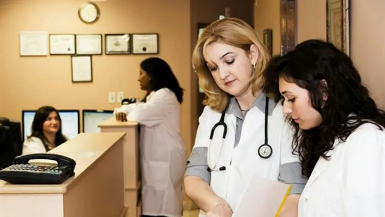 Healthcare staff reviewing provider credentialing records at a clinic desk