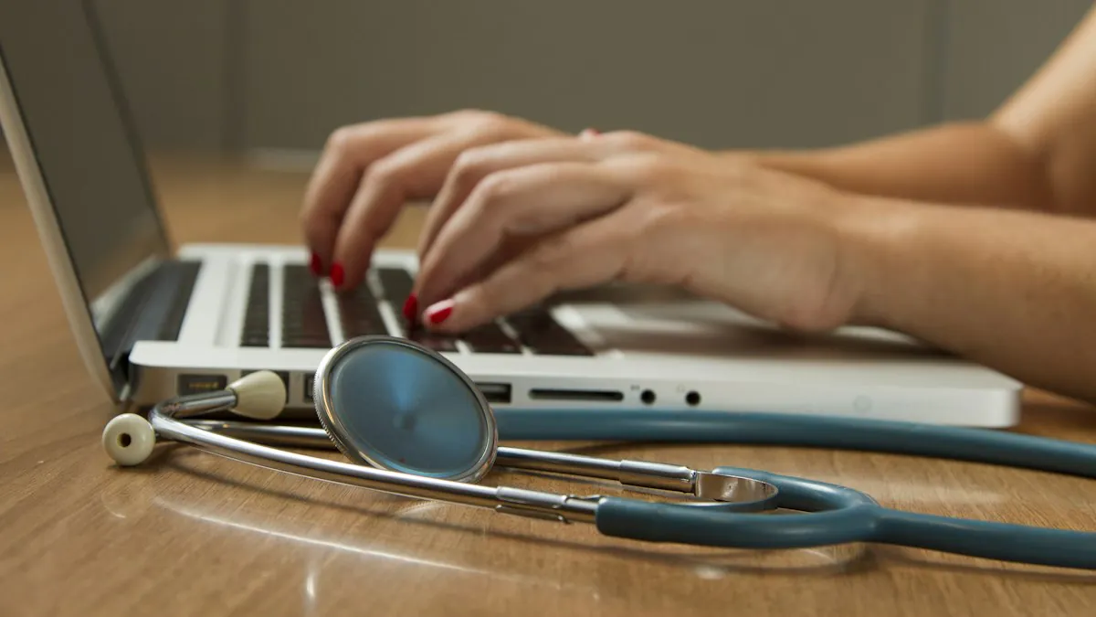 Hands typing on a laptop beside a stethoscope while updating provider data